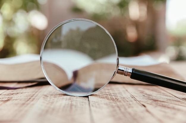 Photo book and magnifier on wooden table