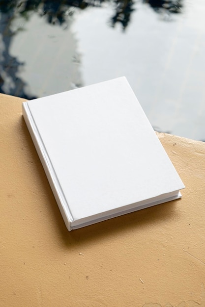 book mockup on wooden floor near pool or pond