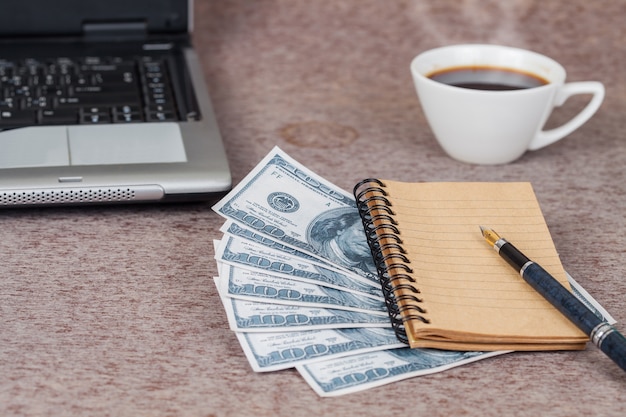 book note and laptop with money on table