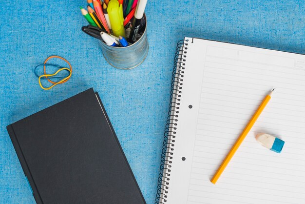 Photo book and notebook near cup with stationery