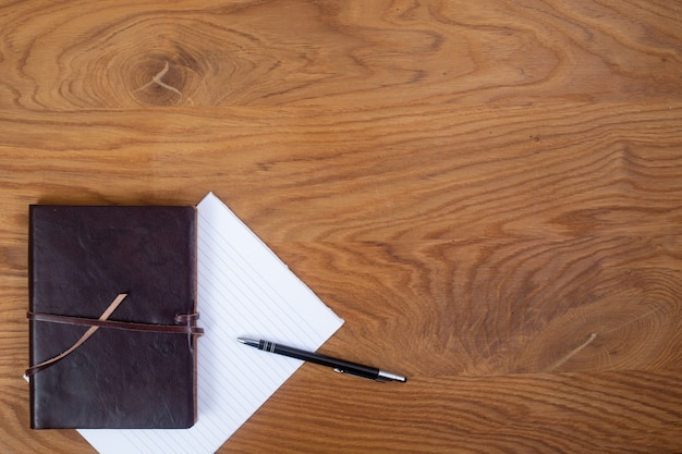 Photo book, notepad and pen on the table