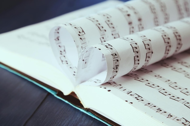 Photo book pages curved into heart shape on table close up