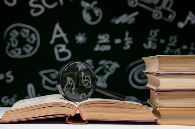 Book stack on a green blackboard background, back to school concept