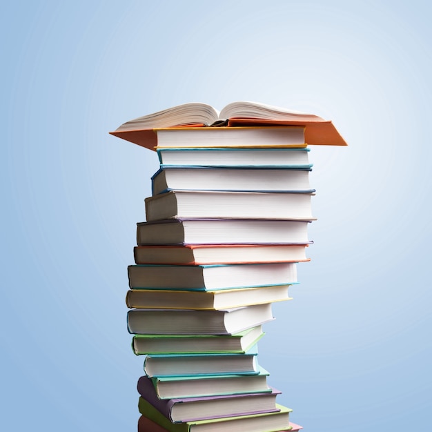 Photo book stacking. open book, hardback books on wooden table and blue background. back to school.