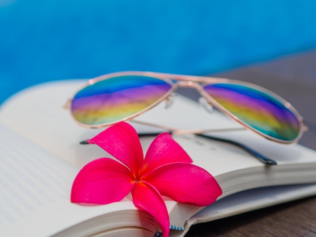 Book and sunglasses, blue water background