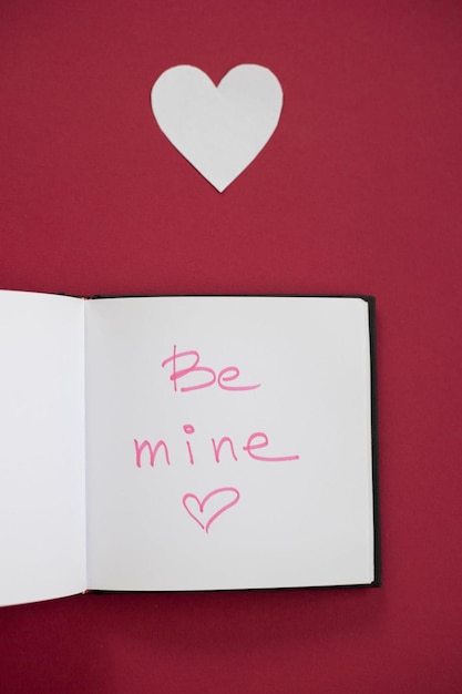 A book with a heart that says be mine.