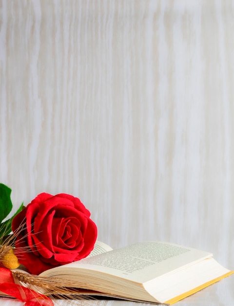 A book with a red rose on it and a yellow flower on the top.