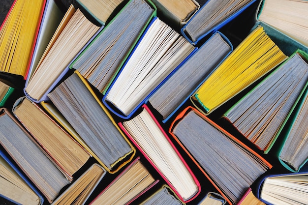 Фото Книги, фон из старых потрепанных книг с цветной бумагой.