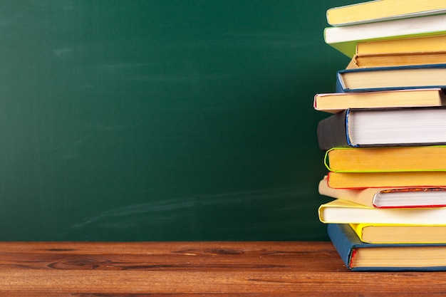 Books on Desk, Chalkboard Background with copyspace