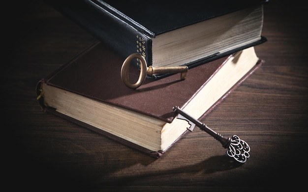 Books and old keys on the wooden table.