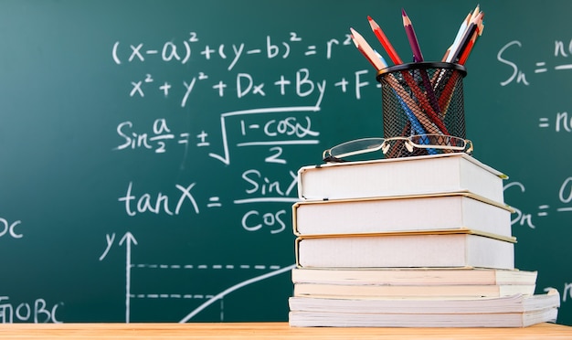 Photo books, and pencils on the desk by the blackboard