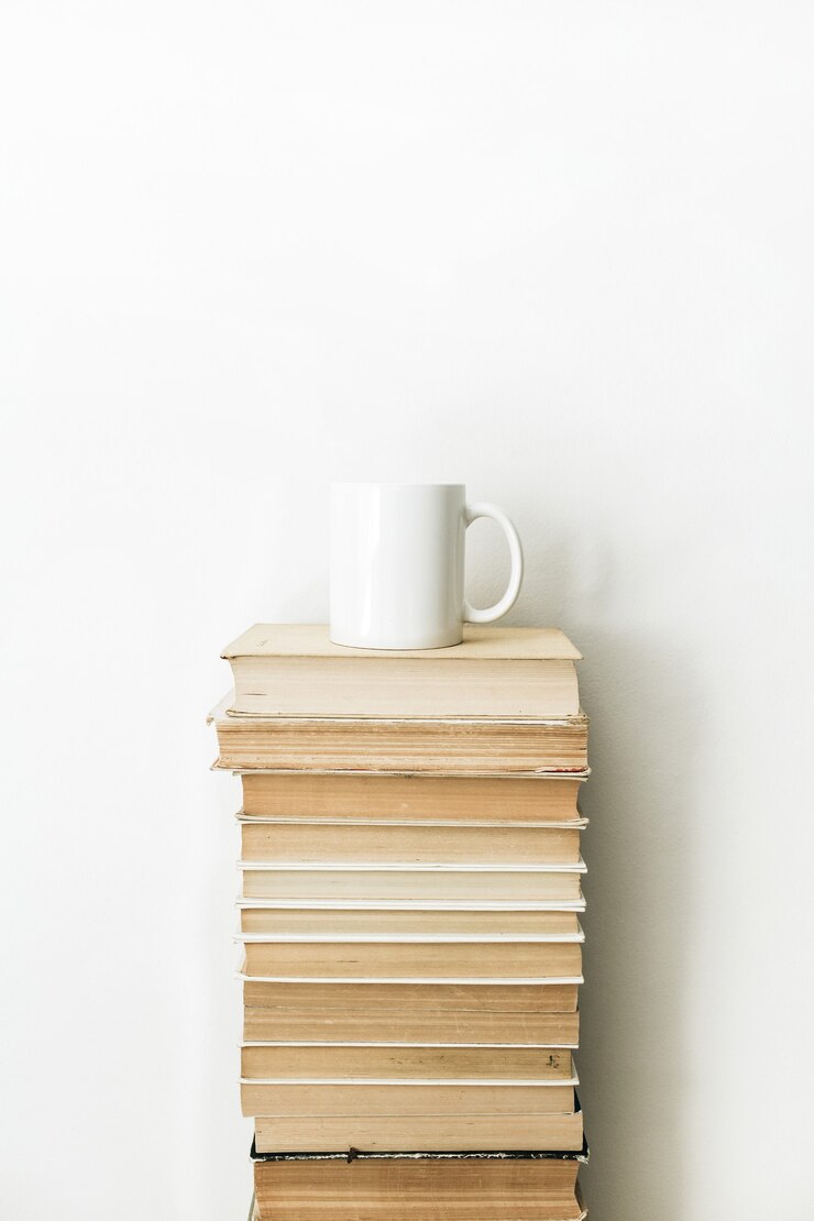 Photo 白い表面に本の山とコーヒーマグ