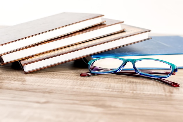 Books and reading glasses on wooden table