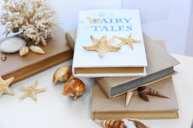 Books and seashells on the table in the room