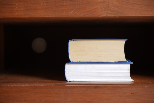 Books stack in dark brown cabinet shelf for education background