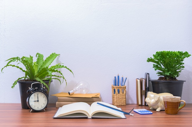 Books and stationery are on the desk in the office