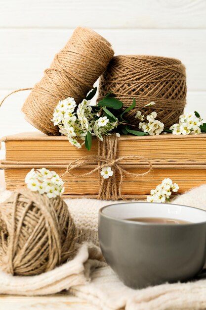 Books twine and cup of tea on white background