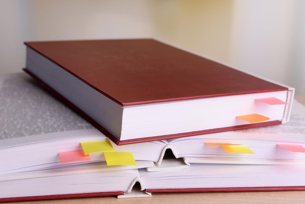 Books with bookmarks on table on bright background