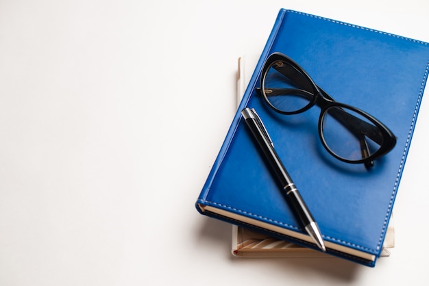 Books with glasses and pen