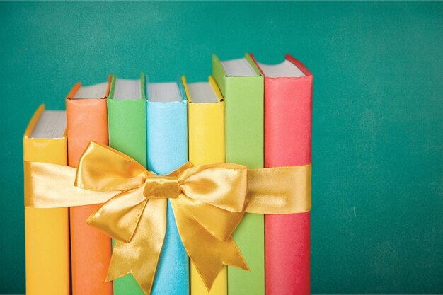 Photo books with golden ribbon on chalkboard background