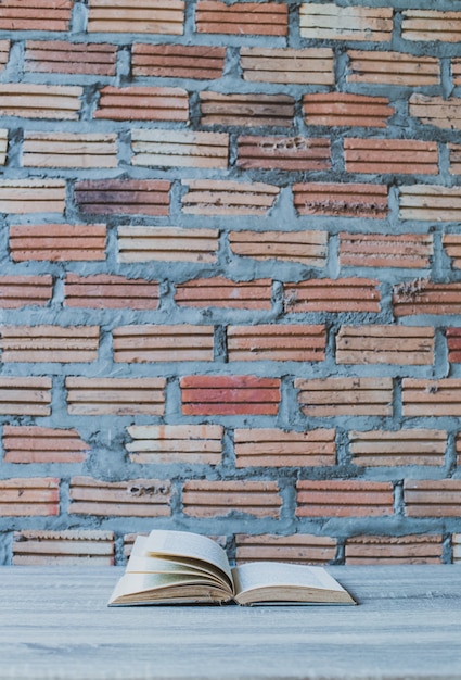 Books on wooden ladder on color wall background