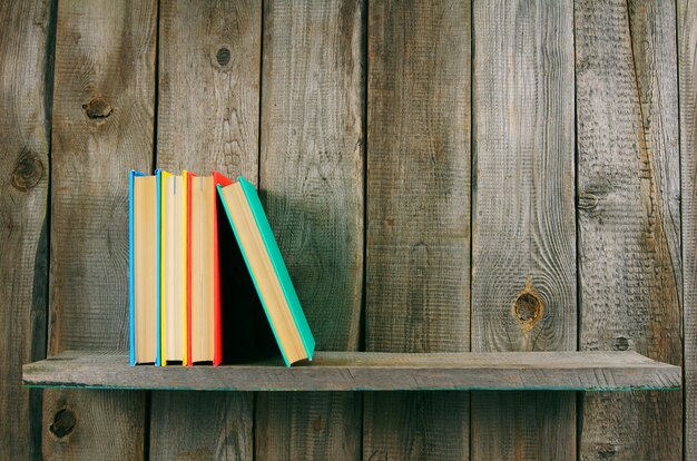 Books on wooden shelf on wooden table.