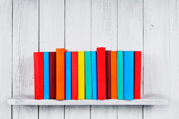 Books on a wooden shelf. On a wooden, white background.