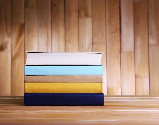 Photo books on wooden table on wooden wall background