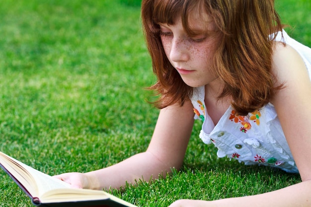 Books.Young mooi meisje dat een boek buiten leest