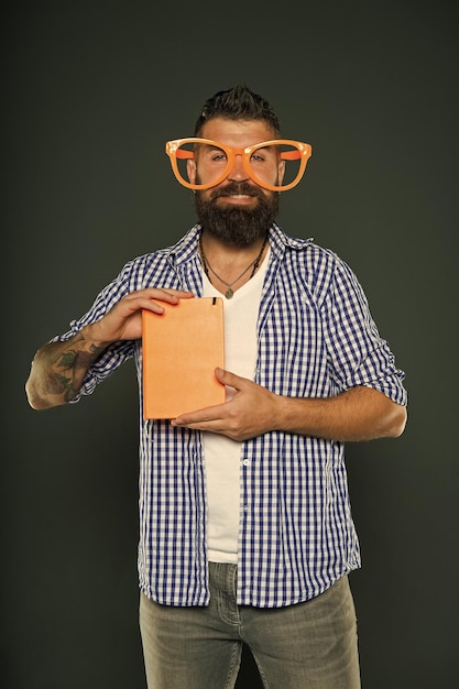 Photo bookworm book nerd wearing fancy glasses study nerd holding book university male student with lecture notes bearded man in party glasses with lesson book