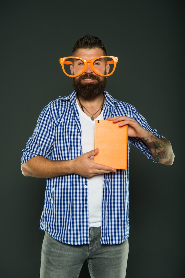Photo bookworm. book nerd wearing fancy glasses. study nerd holding book. university male student with lecture notes. bearded man in party glasses with lesson book.