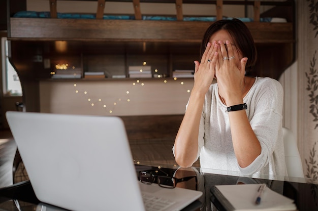 Boos Aziatische vrouw die vanuit thuiskantoor werkt