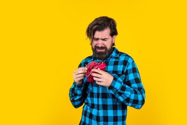 Boos blanke volwassen bebaarde man in casual bedrijf lege portemonnee over gele achtergrond armoede crisis concept