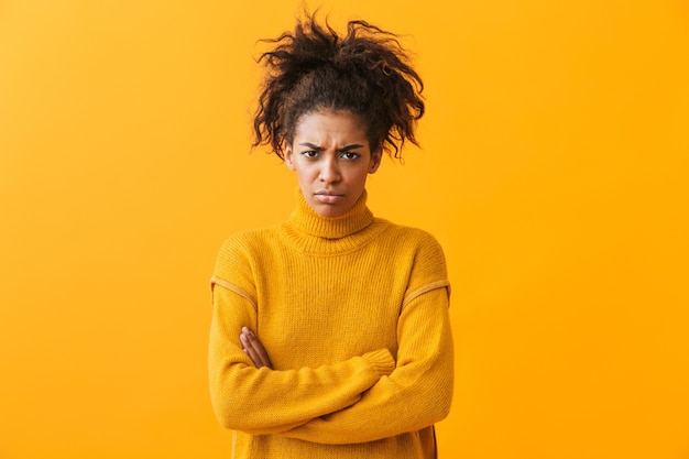 Boos jonge Afrikaanse vrouw, gekleed in trui staande geïsoleerd