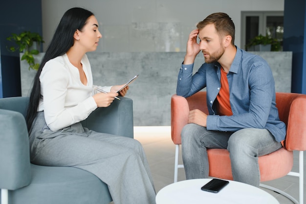 Boos man alcoholist zittend aan psycholoog op psychotherapie sessie verdrietig depressief verslaafd dronken man alcoholverslaving misbruik alcoholisme concept Sociale dienst psychologie patiënt