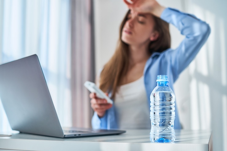 Foto boos moe werkende vrouw die lijden aan hitte en warm weer tijdens online werk op de computer op warme zomerdag