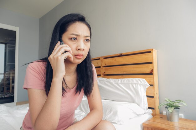 Boos vrouw heeft een telefoongesprek op haar bed.