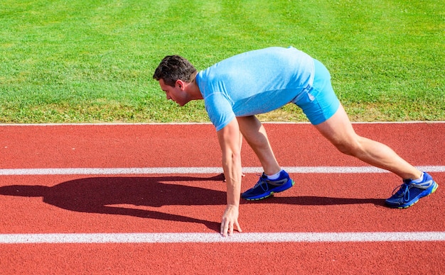 Boost speed concept Man athlete runner push off starting position stadium path sunny day Runner captured in motion just after start of race Runner sprint race at stadium How to start running