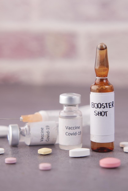 Booster shot-dosis coronavirusvaccin en spuit op blauw