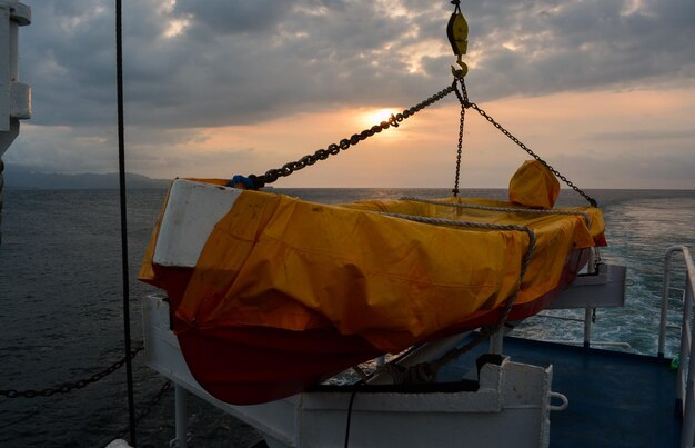 Foto boot aan het strand tegen de hemel bij zonsondergang