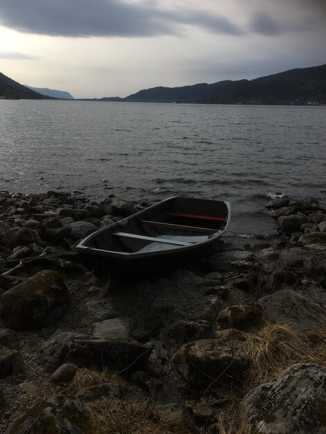 Foto boot aangemeerd op het strand tegen de lucht