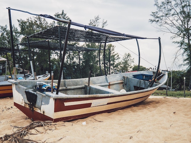 Foto boot aangemeerd op het strand tegen de lucht