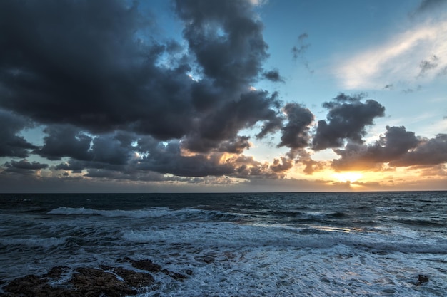 Boot bij zonsondergang onder donkere wolken