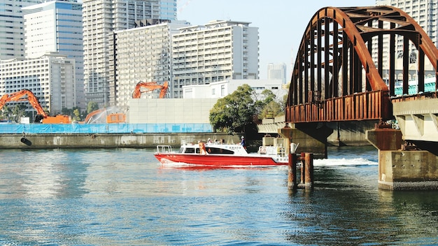 Boot die in de rivier onder de brug beweegt naar stad