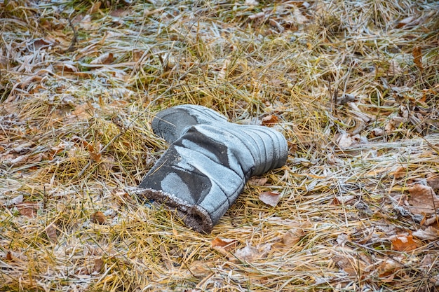 Ботинок в морозной траве, брошенный сапог, потерянный ботинок