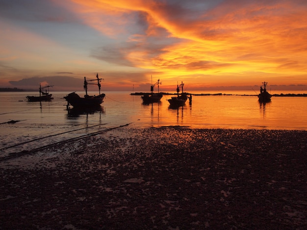 Boot op het strand bij zonsopgang in getijdetijd