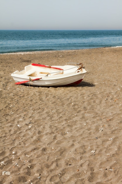 Boot op het strand Skyline Een kleine houten boot die door vissers wordt gebruikt op het zandstrand naast de Middellandse Zee