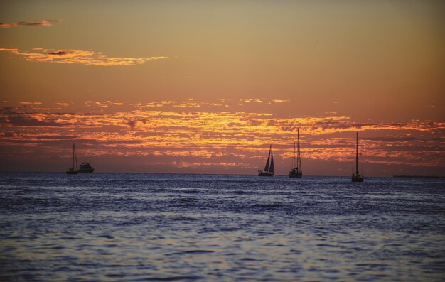 Boot op zee bij zonsondergang zeilboten met zeilen oceaanjacht langs water