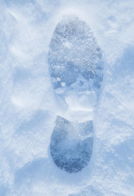 Boot print in the snow winter one close up