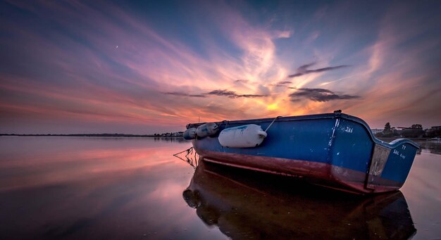 Foto boot verankerd in de zee bij zonsondergang